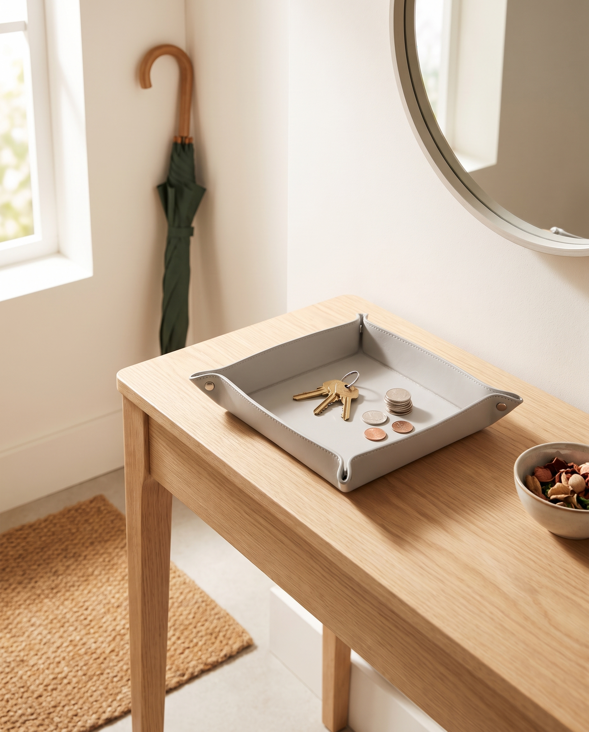 Entrada minimalista con bandeja de cuero gris claro Vesta Home Hub sobre mesa consola, vista amplia